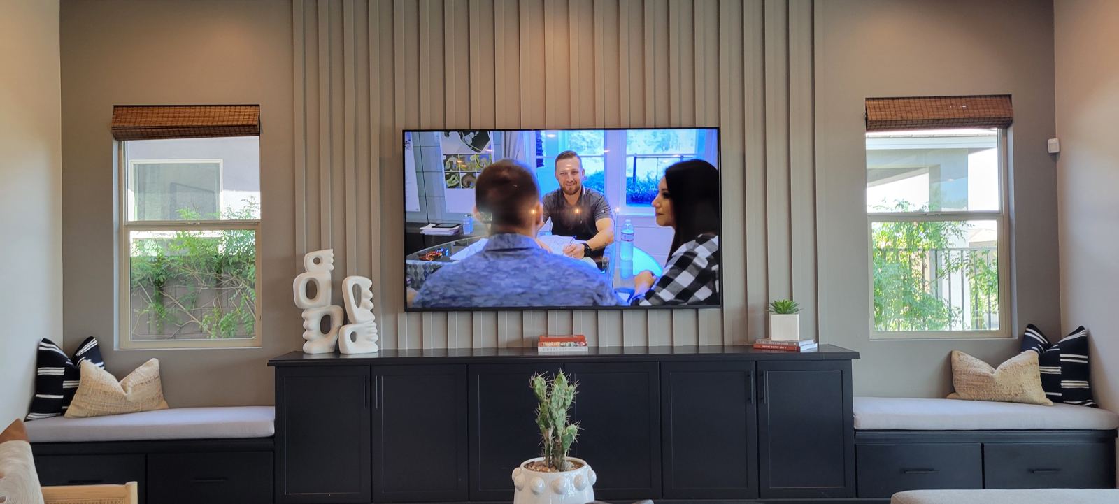 TV mounted on a slat wall with built-in cabinetry