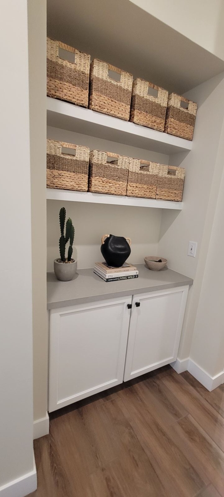 Laundry alcove with cabinets and floating shelves
